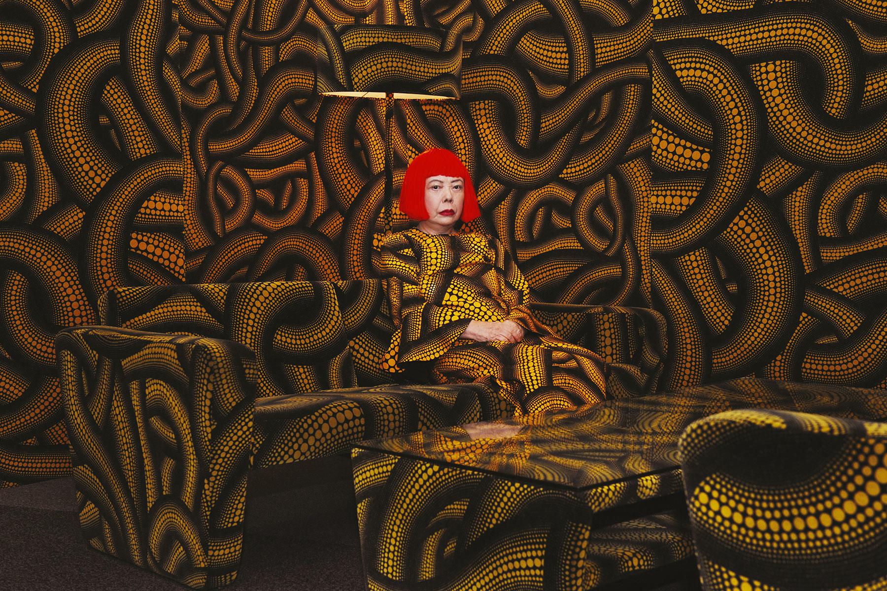 The meme is a screenshot of a woman (likely a celebrity) sitting in a room filled with her own artwork, specifically her 2013 exhibition "Roppongi Hills" in Tokyo. The image is captioned "I can smell the desperation radiating from this room". The meme is likely poking fun at the artist's obsessive personality and the overwhelming nature of her work.
